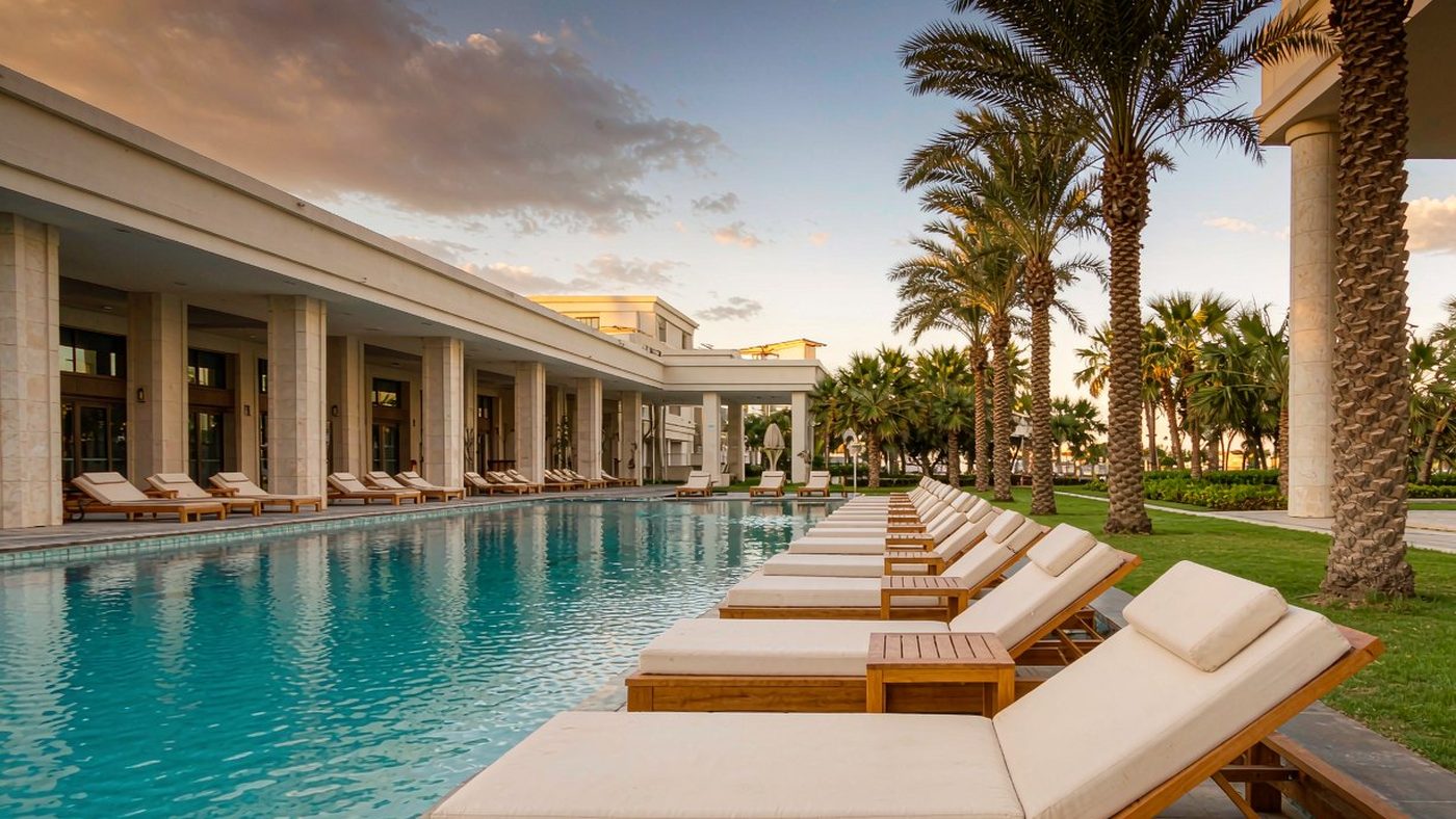 Resort pool deck with sun loungers and side tables