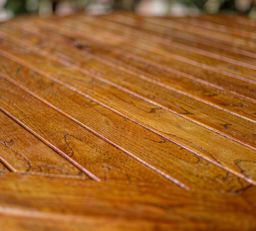 Close-up of an oiled solid teak tabletop showing wide slats and visible grain